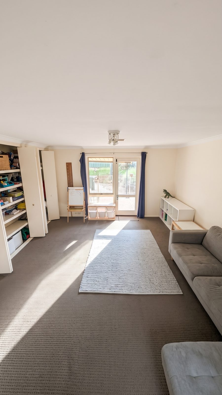 A family living room photographed on a phone, tidied